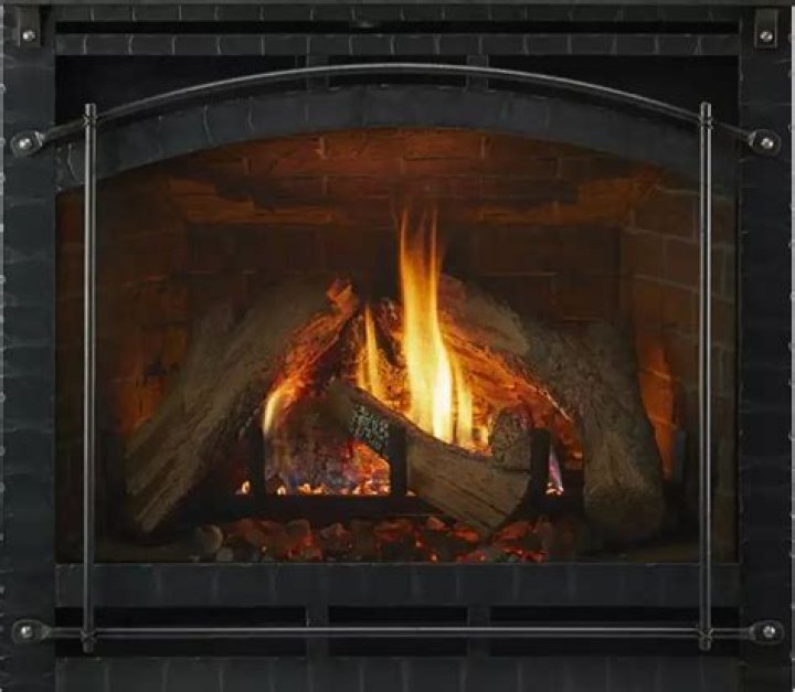 How do you adjust the flame on a Heat and Glo fireplace?