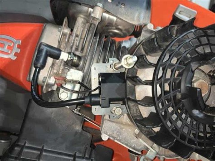 What does the ignition coil do on a lawn mower?